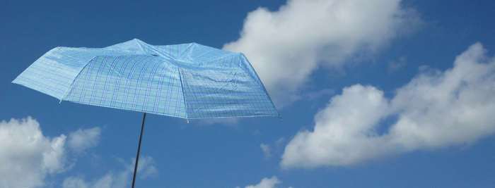 Blue umbrella against a cloudy sky