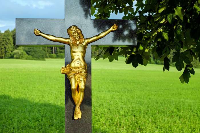 Golden Jesus on a Stone Cross in a Field 4K