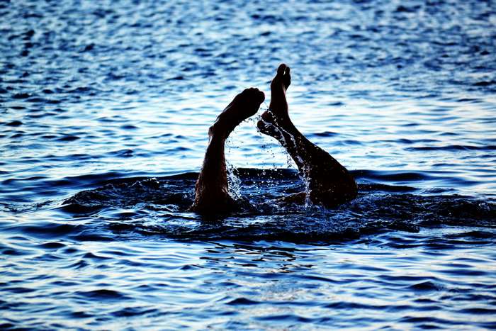 Person's feet splashing in the ocean water