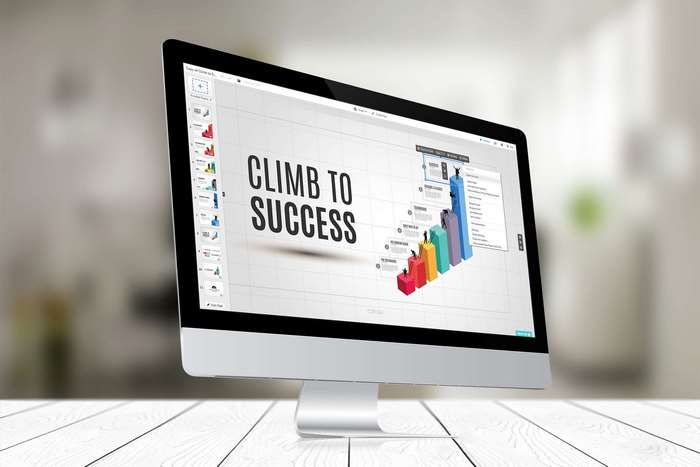 Computer monitor displaying a presentation titled "Climb to Success" with a bar graph.