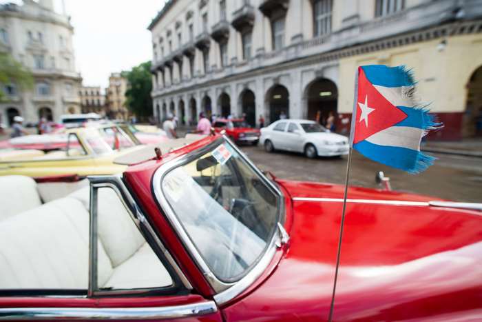 Vintage cars with Cuban flag in Havana street 4K