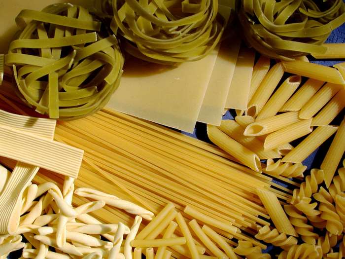 Assortment of dry pasta types including penne, spaghetti, and lasagna sheets