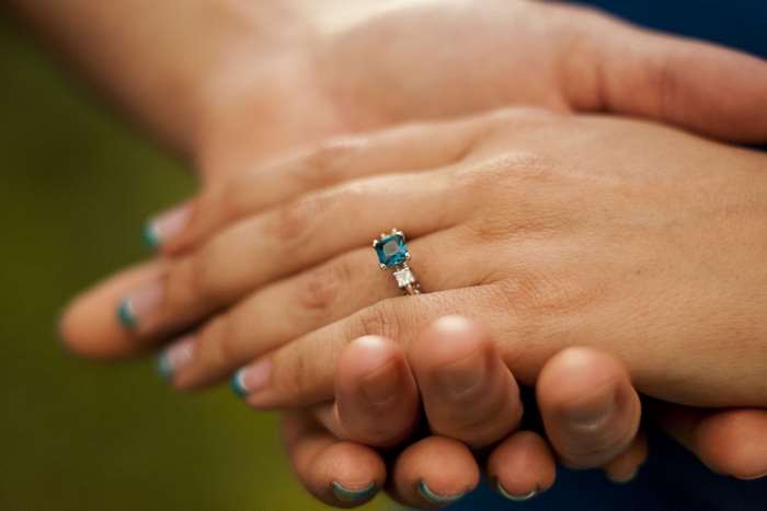 Engagement ring with blue stone on hand