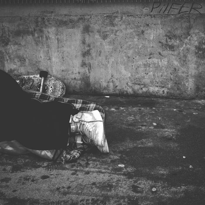 Person sleeping on skateboard with sneakers