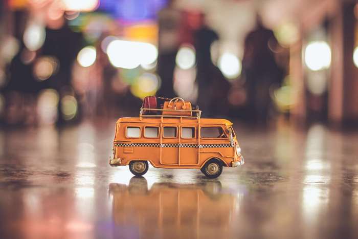Orange toy bus with luggage on roof