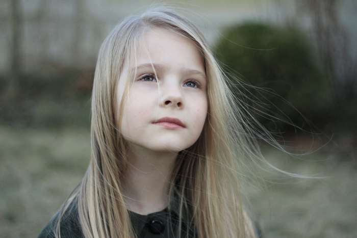 Portrait of a young blonde girl looking up
