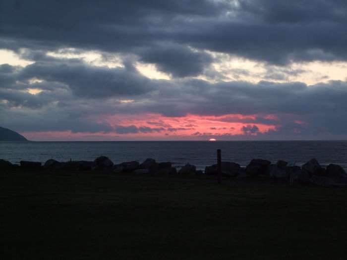 Sunset over the ocean with dark clouds