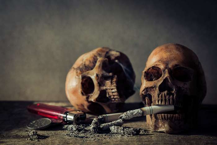 Still life with skulls, cigarettes, and lighter