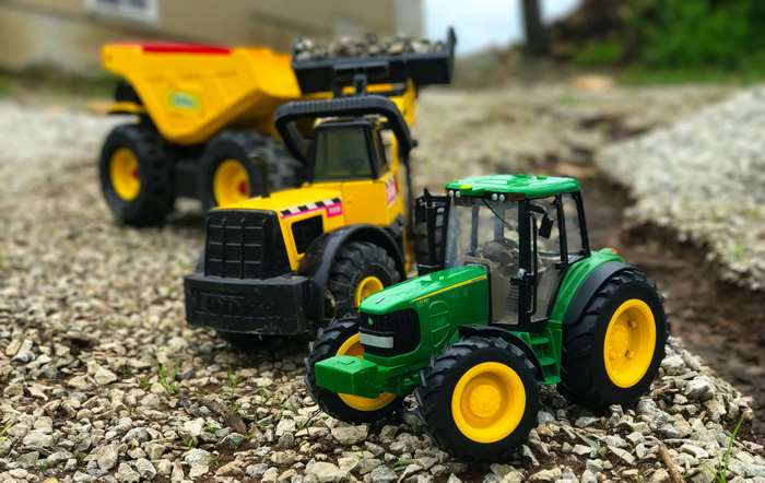 Yellow dump truck and green John Deere tractor