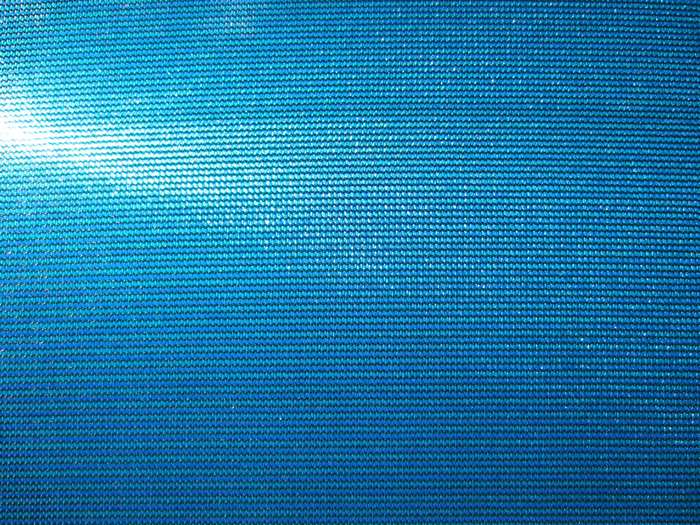 Blue textured fabric with sunlight reflection