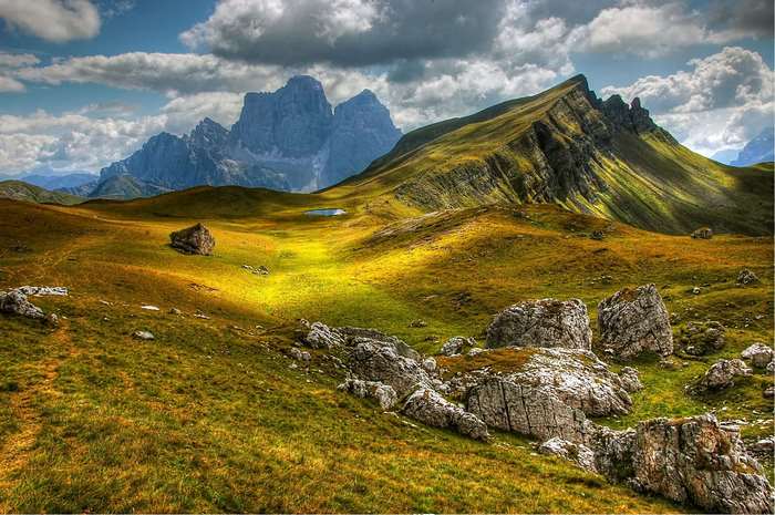 Grassy mountain landscape with rocky outcrops and distant peaks