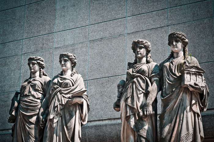 Four stone statues in front of a building