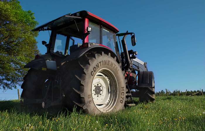 Red tractor with large tires in a grassy field