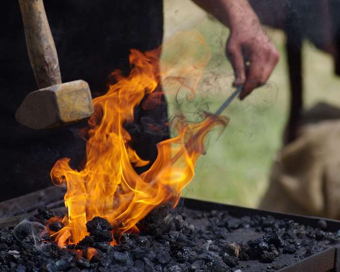 Blacksmith working with hammer and fire in a forge 4K