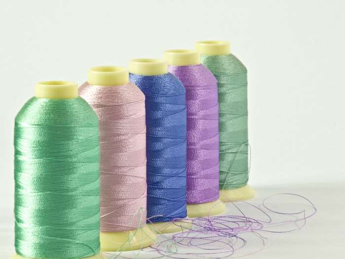 Colorful spools of sewing thread on a white background