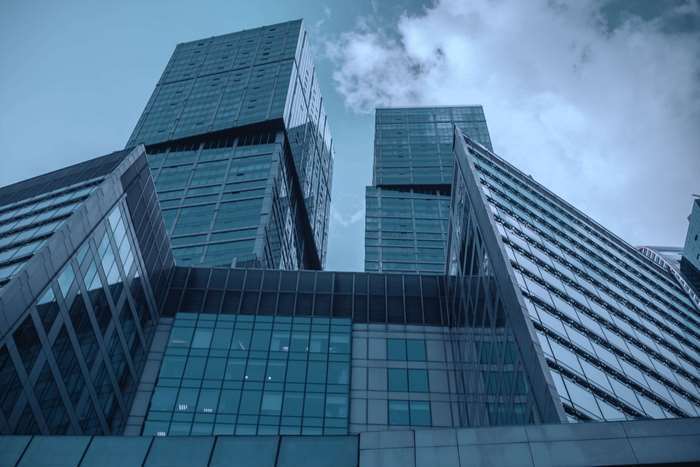 Modern glass skyscrapers against a cloudy sky