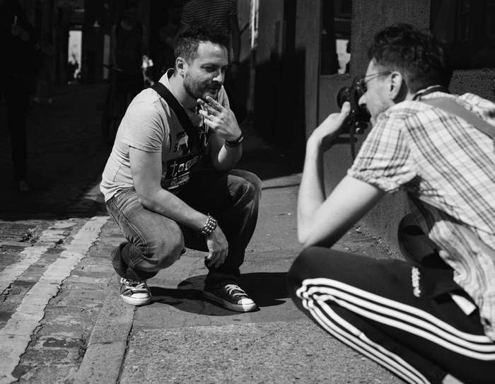 Man posing for a photographer on a street