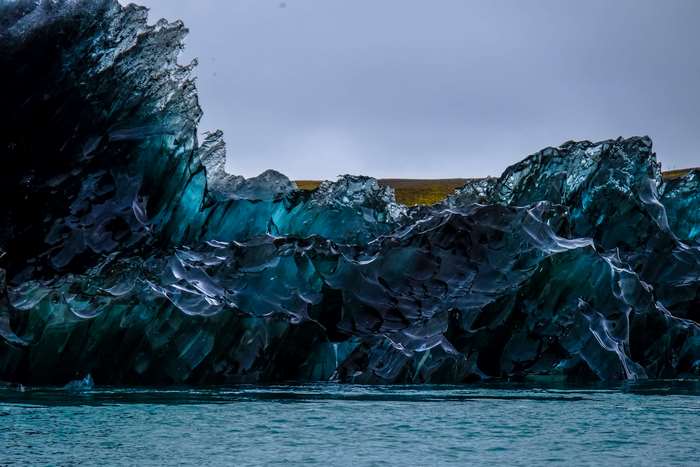 Dark blue iceberg floating in calm water
