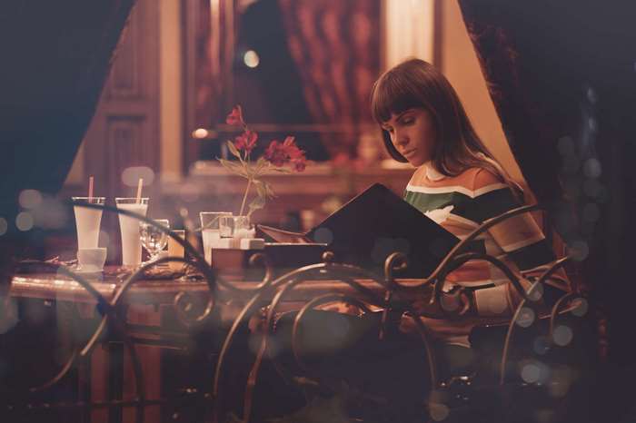 Woman reading a menu in a restaurant at night