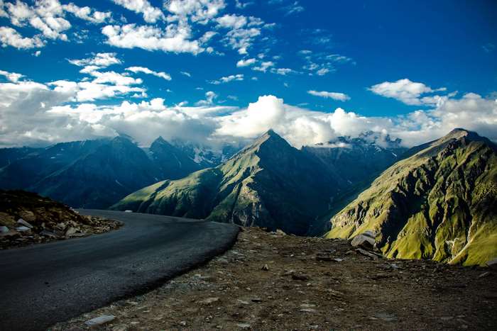 Scenic mountain road with clouds and blue sky