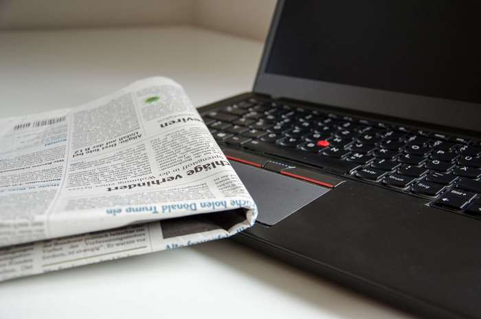 Newspaper and Laptop on a Desk