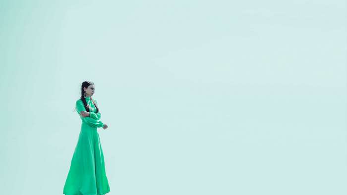Woman in green dress on a light blue background