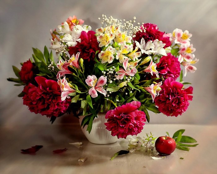 Still life of peonies, alstroemeria, and gypsophila in a vase with an apple