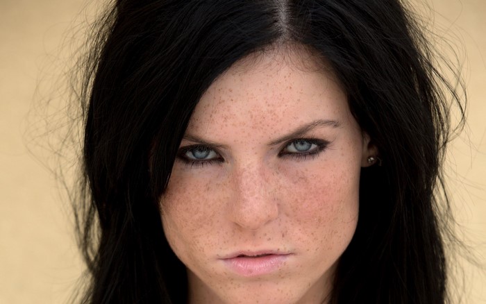 Close-up of a blue-eyed brunette woman with freckles