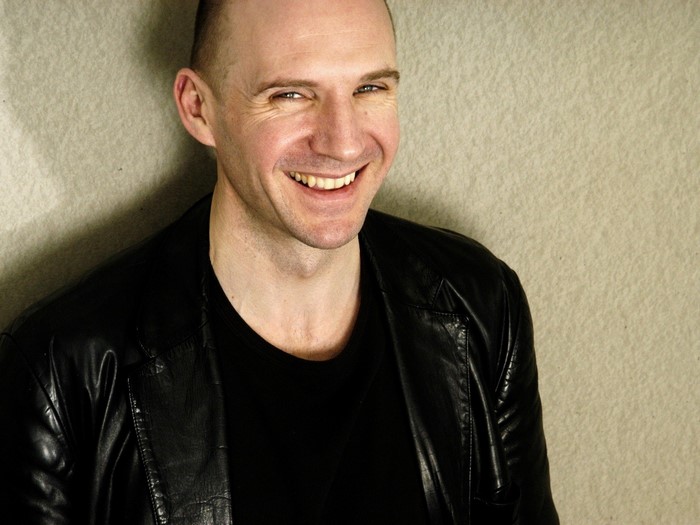 Ralph Fiennes smiling in a black jacket