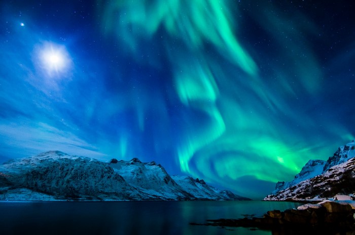Aurora Borealis over snow-capped mountains and water