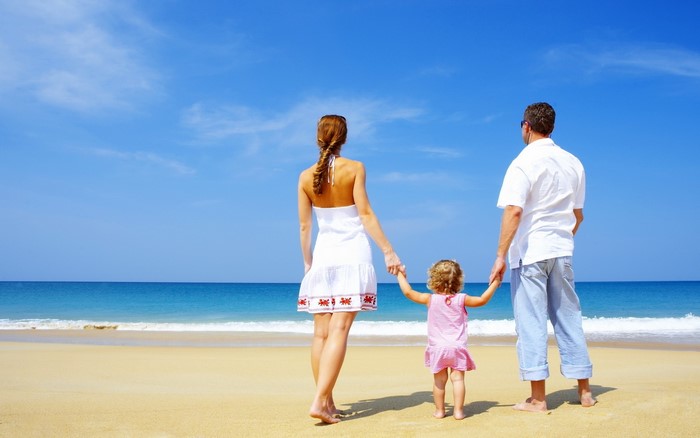 Family on a sandy beach looking at the sea