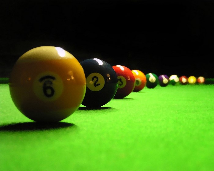 Billiard balls lined up on a green table