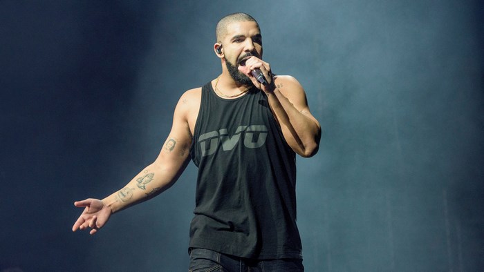 Drake performing on stage wearing a black tank top