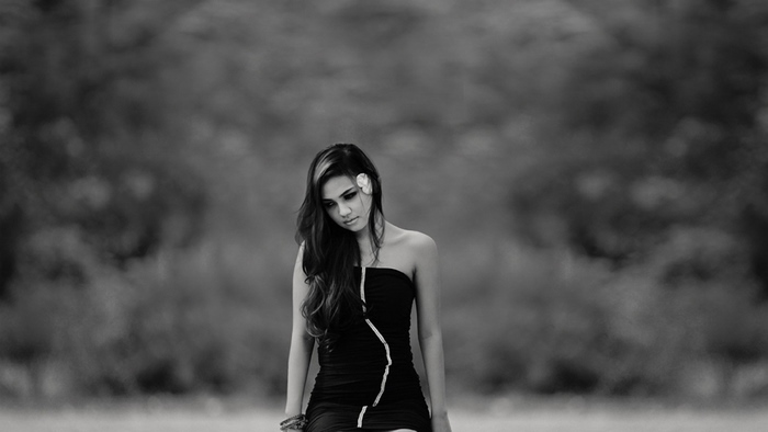 Monochrome portrait of a sad girl with a flower