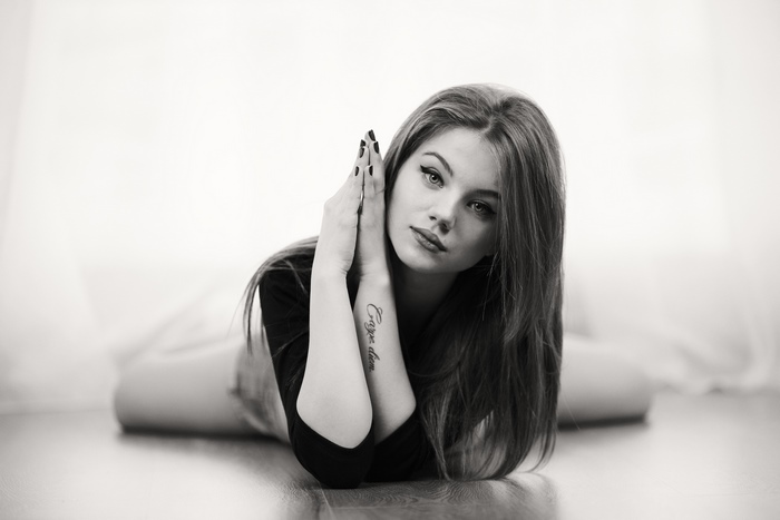 Woman with long hair and tattoo lying down