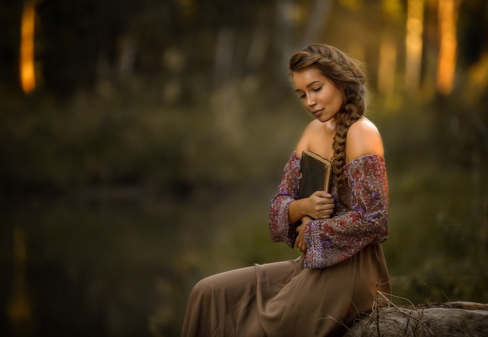 Woman with book in forest