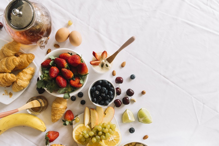 Breakfast spread with croissants, fruits, and tea