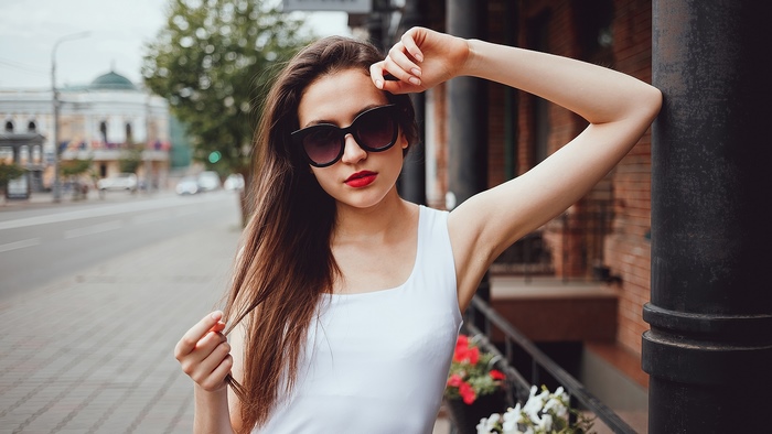 Woman with long brown hair and sunglasses