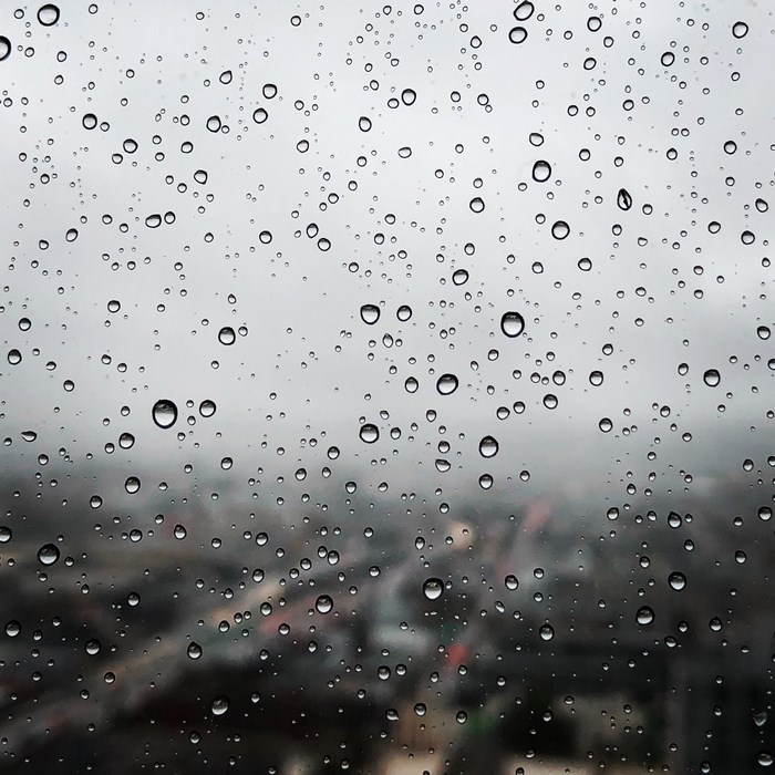 Raindrops on a window overlooking a city