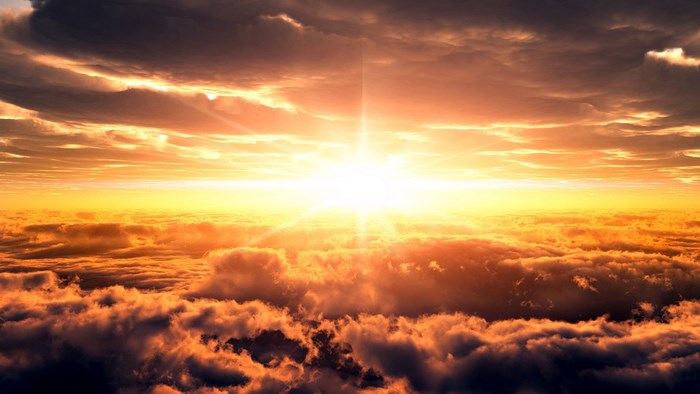 Sunset over clouds with sunburst