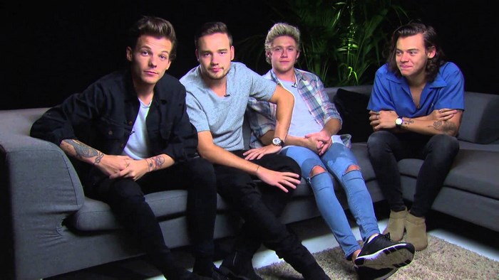 One Direction sitting on a couch