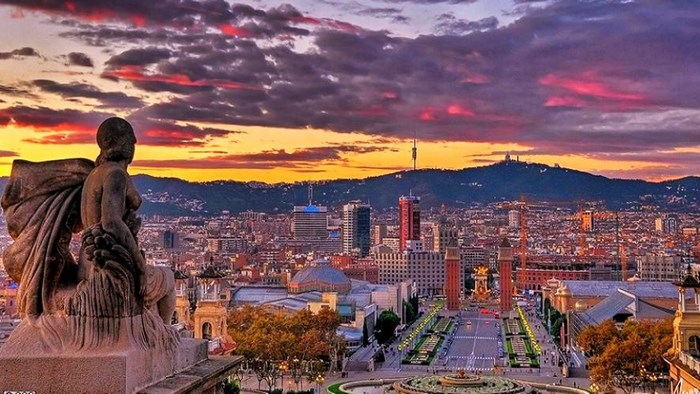 Barcelona cityscape at sunset with statue foreground