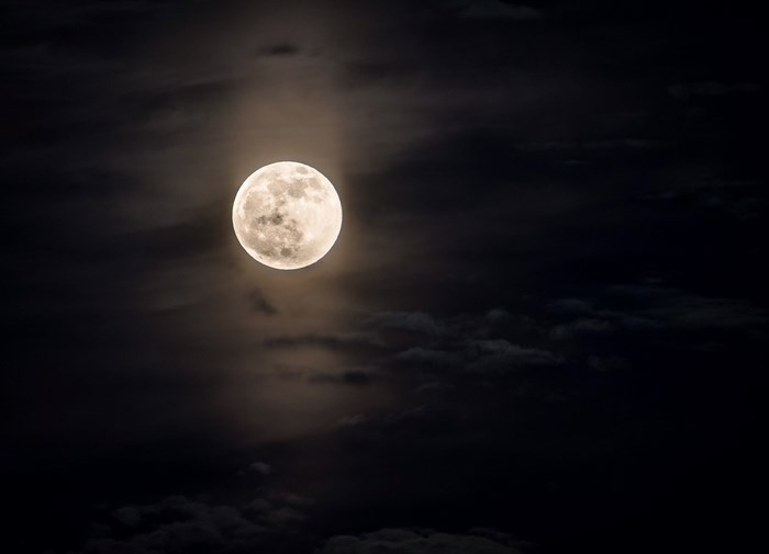 Full moon in a cloudy night sky