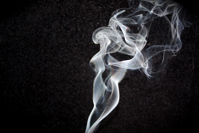 White smoke swirling against a black background