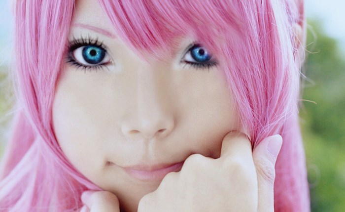 Close-up of a young woman with pink hair and blue eyes