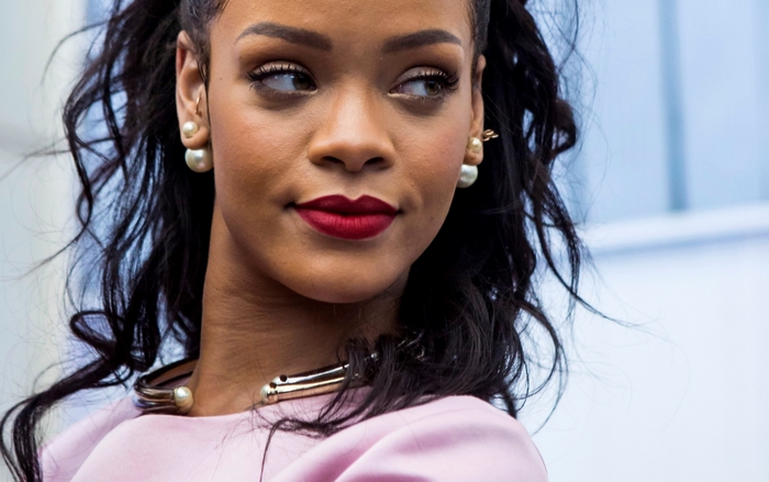 Rihanna wearing a pink dress and pearl earrings