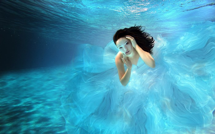 Woman in blue dress underwater