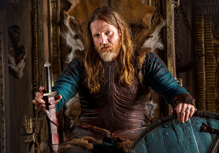 Man in Viking Armor Sitting on Throne with Sword
