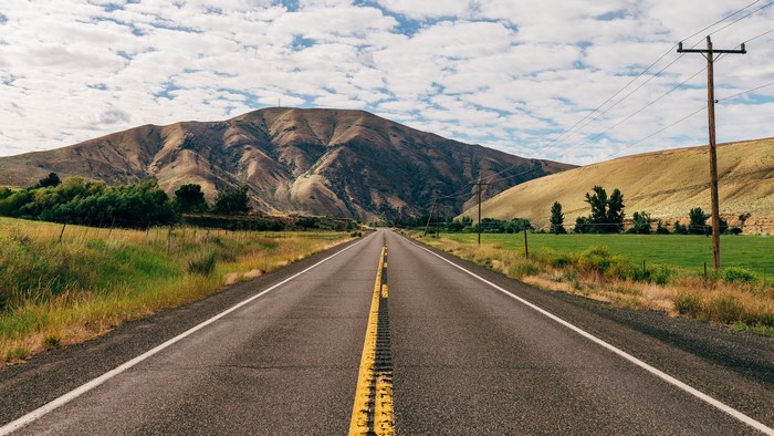 Empty highway leading to a mountain