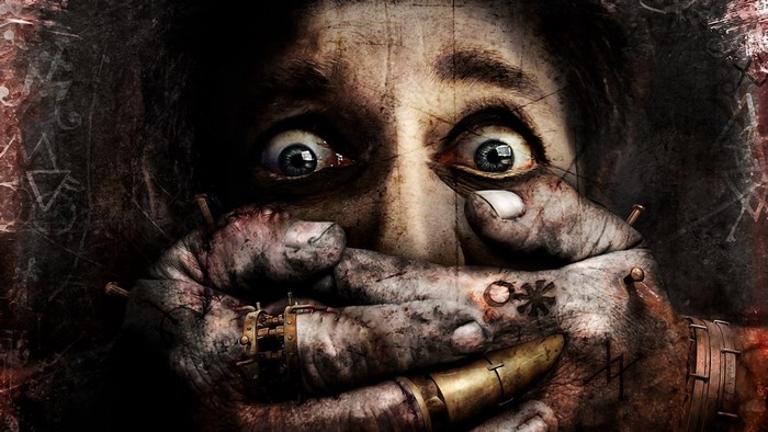 Close-up of a person with eyes wide in fear, hands covering their mouth